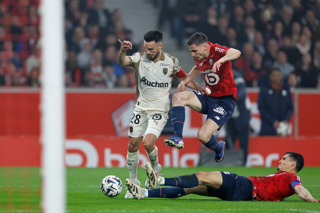 Lens' Adrien Thomasson, left, and Lille's Aissa Mandi, down, challenge for the ball during the French League One soccer match between Lille and Lens, in Lille, France, Saturday, April 4, 2026. (AP Photo/Jean-Francois Badias)