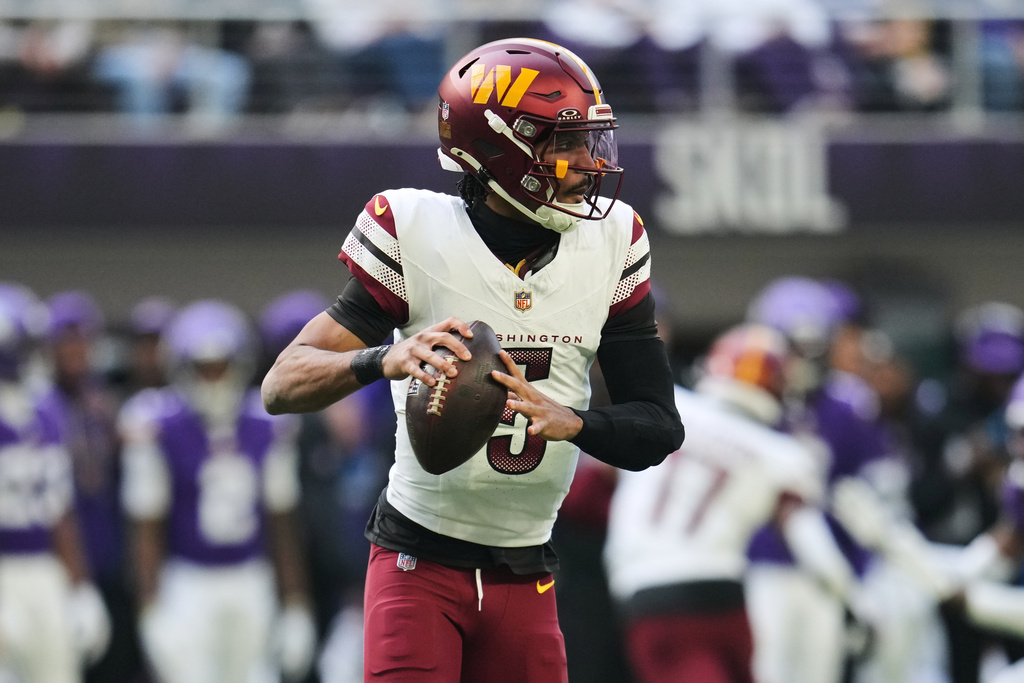 Washington Commanders quarterback Jayden Daniels looks to pass during the first half of an NFL football game against the Minnesota Vikings, Sunday, Dec. 7, 2025, in Minneapolis. (AP Photo/Abbie Parr)