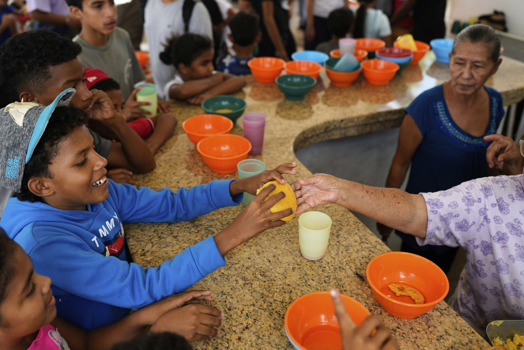 A youth eats at the San Judas Tadeo church soup kitchen for neighborhood children in Coro, Venezuela, Saturday, June 28, 2025. (AP Photo/Ariana Cubillos)