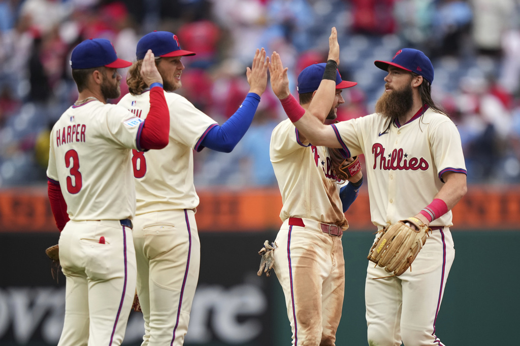 Philadelphia Phillies' Bryce Harper, from left, Alec Bohm, Trea Turner and Brandon Marsh celebrate after the Phillies won a baseball game against the Seattle Mariners Wednesday, Aug. 20, 2025, in Philadelphia. (AP Photo/Matt Slocum)