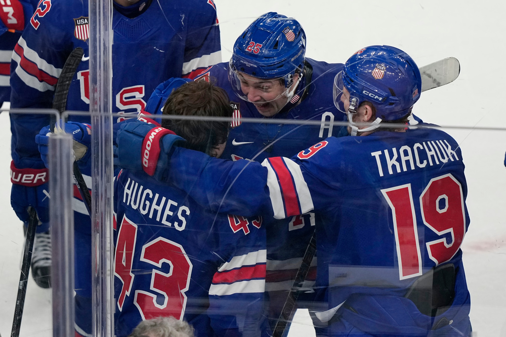 United States' Charlie McAvoy (25) and Matthew Tkachuk (19) celebrate with Quinn Hughes (43), who scored the winning goal to beat Sweden in overtime in a men's ice hockey quarterfinal game at the 2026 Winter Olympics, in Milan, Italy, Wednesday, Feb. 18, 2026. (AP Photo/Hassan Ammar)
