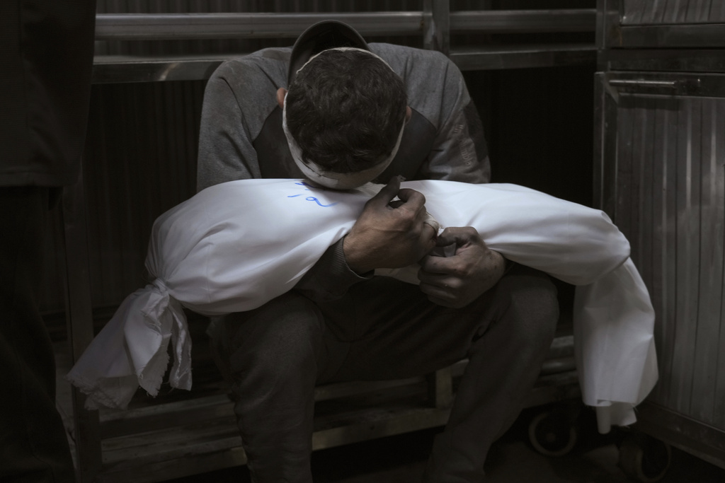 Hossam Azzam holds the body of his child, Amir, who was killed in an Israeli military airstrike on Gaza, at Shifa Hospital in Gaza City Tuesday, July 15, 2025. (AP Photo/Jehad Alshrafi)