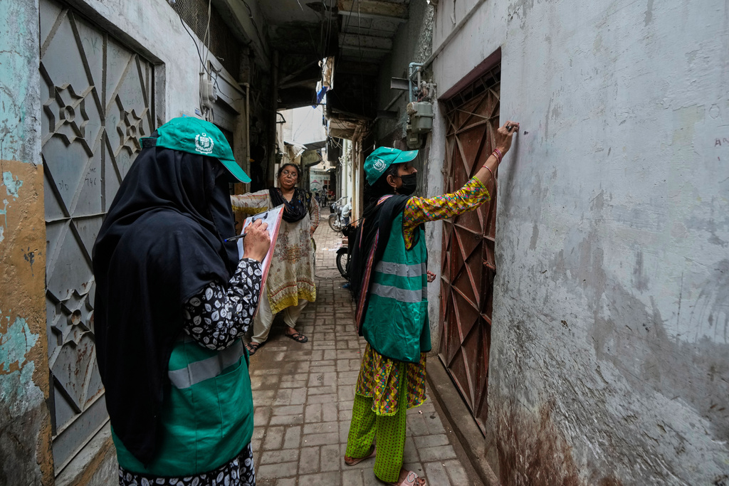 A heath worker marks on the wall of a home during a human papillomavirus (HPV) vaccination campaign aiming to protect girls from cervical cancer, at a neighbourhood of Karachi, Pakistan, Wednesday, Sept. 24, 2025. (AP Photo/Fareed Khan)