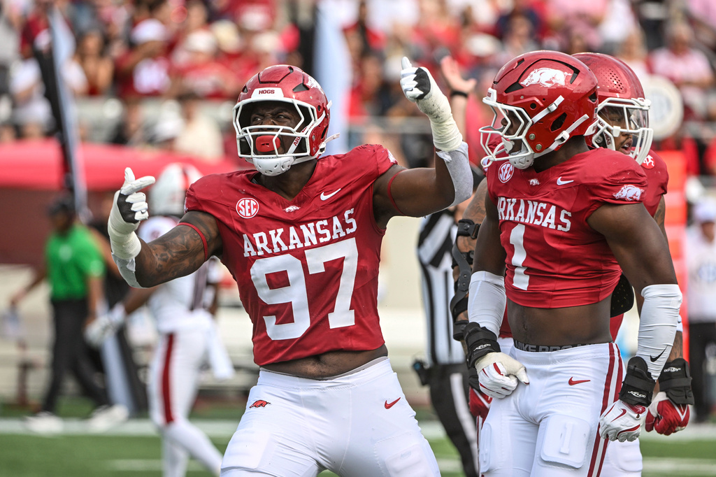 FILE - Arkansas defenders Quincy Rhodes Jr. (97) and Phillip Lee (1) celebrate after a big defensive stop against Arkansas State during an NCAA football game, Sept. 6, 2025, in Little Rock, Ark. (AP Photo/Michael Woods, File)