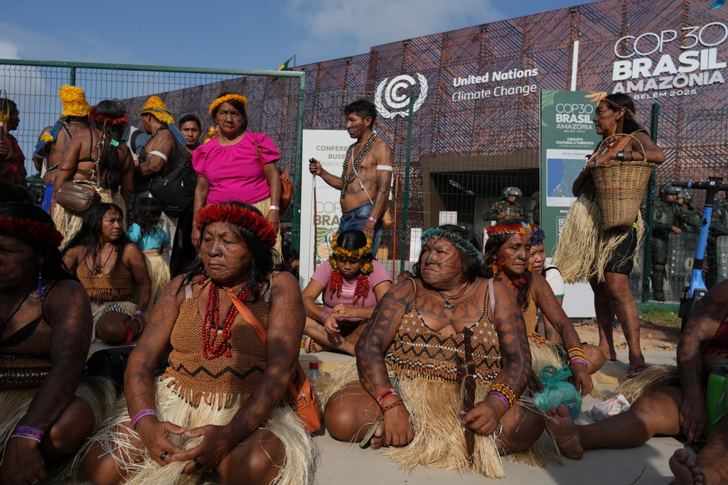 An Indigenous group blocks an entrance to the COP30 U.N. Climate Summit, Friday, Nov. 14, 2025, in Belem, Brazil. (AP Photo/Andre Penner)