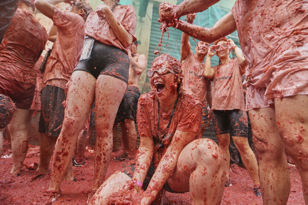 Revelers throw tomatoes at each other during the annual "Tomatina" tomato fight fiesta, in the village of Bunol near Valencia, Spain, Wednesday, Aug. 27, 2025. (AP Photo/Alberto Saiz)