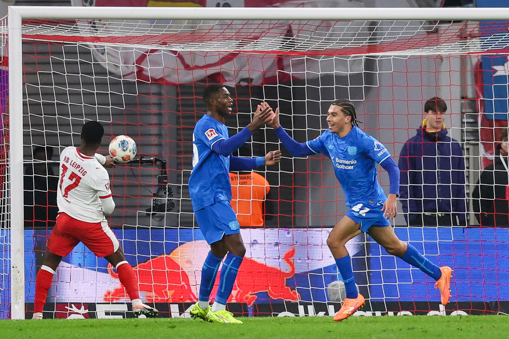 Montrell Culbreath of Bayer Leverkusen, right, celebrates after scoring to make it 1:3 during the Bundesliga soccer match between RB Leipzig and Bayer Leverkusen, in Leipzig, Germany, Saturday Dec. 20, 2025. (Jan Woitas/dpa via AP)
