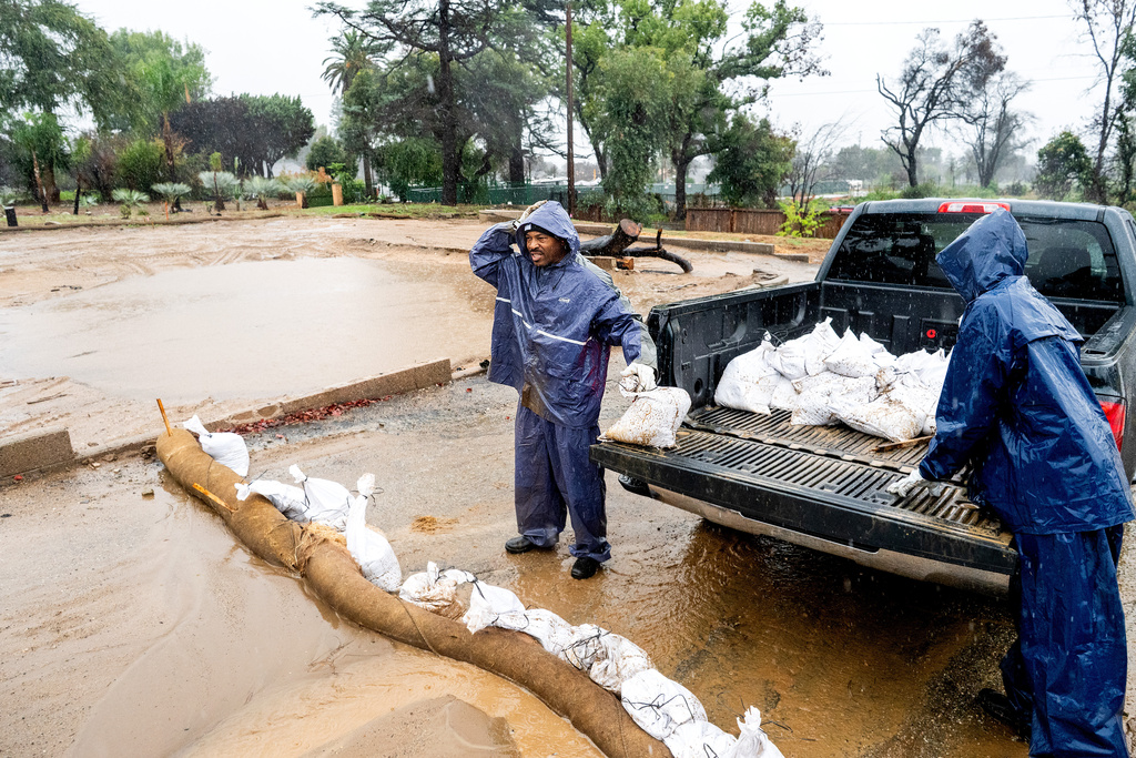 Ronald Jones surveys a property scorched in the Eaton Fire while placing sandbags to prevent mud and water runoff Altadena, Calif., as the region remains under flash flood warnings on Saturday, Nov. 15, 2025. (AP Photo/Noah Berger)