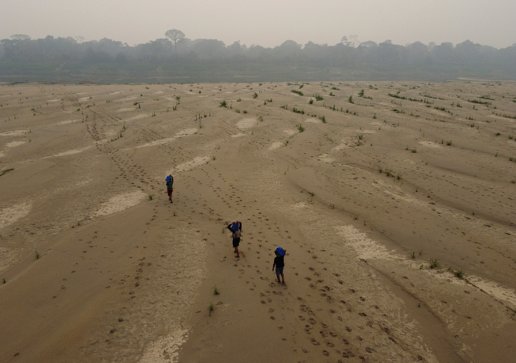 FILE - Residents transport drinking water from Humaita to the Paraizinho community, along the dry Madeira River, a tributary of the Amazon River, during the dry season, Amazonas state, Brazil, Sept. 8, 2024. (AP Photo/Edmar Barros, File)