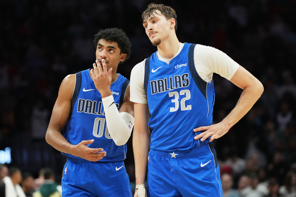 Dallas Mavericks guard Max Christie (00) and forward Cooper Flagg (32) stand together during the last seconds of the second half of an NBA basketball game against the Miami Heat Monday, Nov. 24, 2025, in Miami. (AP Photo/Marta Lavandier)