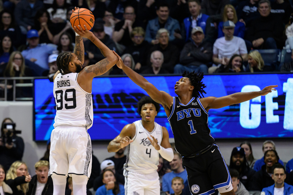 UCF forward Jordan Burks (99) shoots over BYU guard Robert Wright III (1) during the first half an NCAA college basketball game, Tuesday, Feb. 24, 2026, in Provo, Utah. (AP Photo/Tyler Tate)