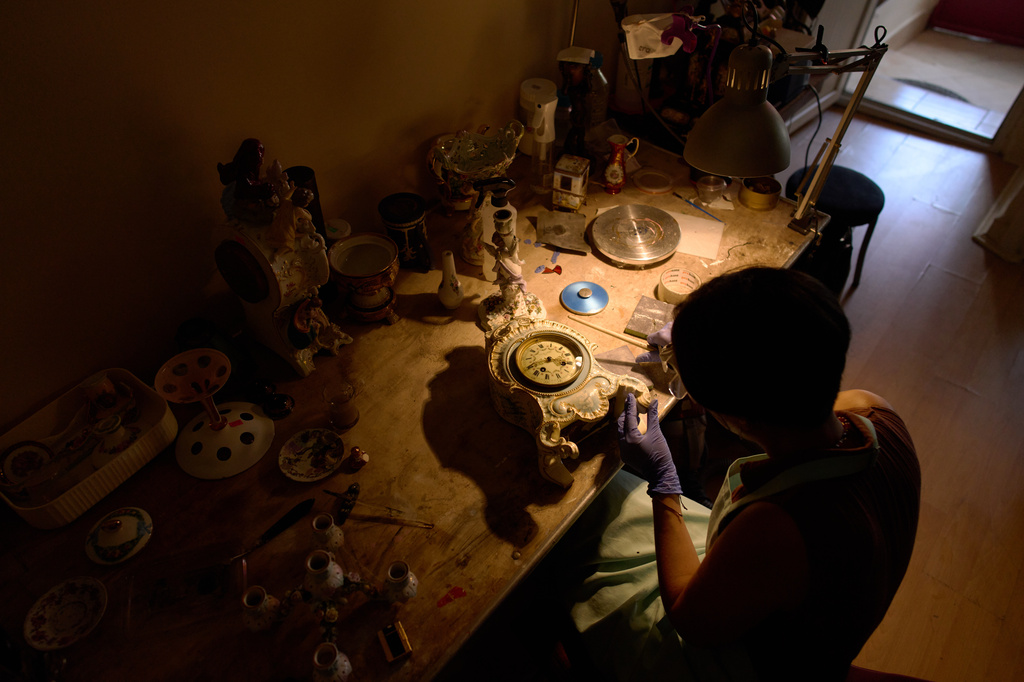 Master restorer and conservator Deniz Karacam works on a ceramic table clock in her workshop in the Balat neighborhood of Istanbul, Turkey, Saturday, Aug. 8, 2026. (AP Photo/Francisco Seco)