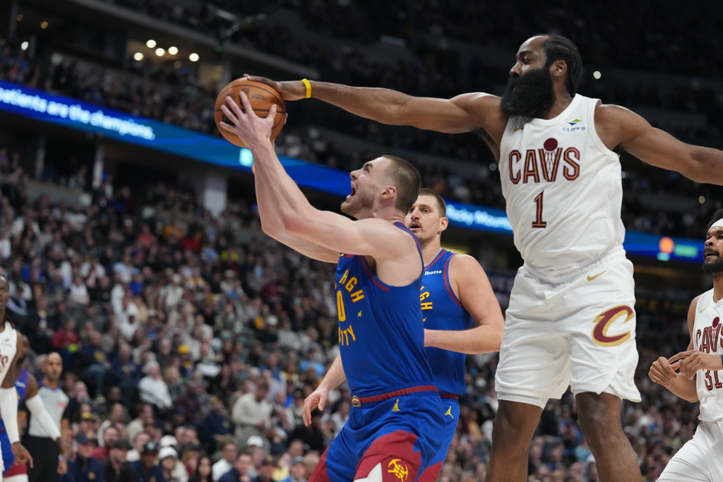 Cleveland Cavaliers guard James Harden, right, goes up to block a shot by Denver Nuggets guard Christian Braun in the first half of an NBA basketball game Monday, Feb. 9, 2026, in Denver. (AP Photo/David Zalubowski)