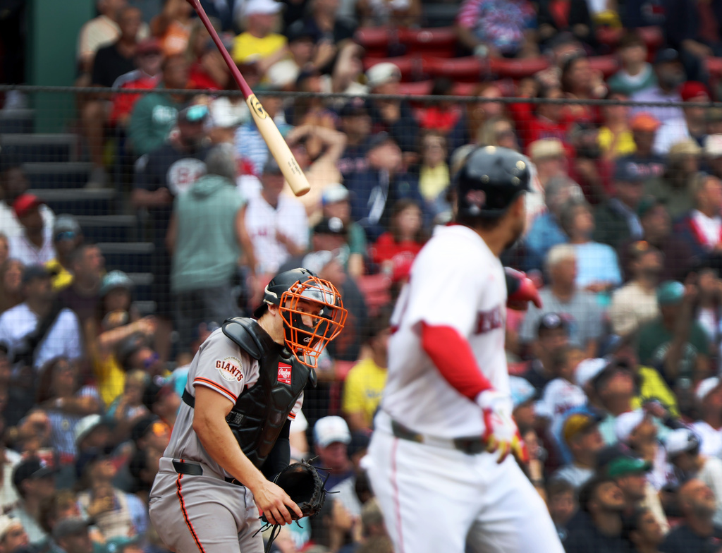The bat of Boston Red Sox's Willson Contreras, right, just misses San Francisco Giants catcher Andrew Knizner, left, in the third inning of a baseball game, Sunday, Aug. 23, 2026, in Boston. (AP Photo/Jim Davis)
