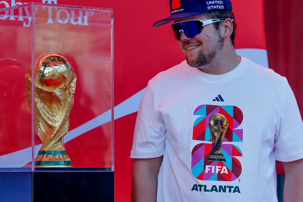 Soccer fan Joseph Pozdnakov has his photo taken during the FIFA World Cup Trophy Tour outside Truist Park before the Atlanta Braves host the Chicago Cubs in a baseball game, Thursday, May 14, 2026, in Atlanta. Eight FIFA World Cup soccer matches will be played in Atlanta.(AP Photo/Erik S. Lesser)