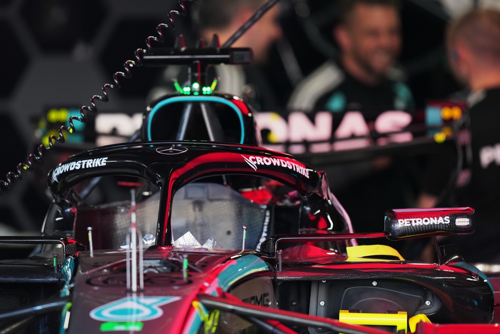 Mercedes driver George Russell of Britain's car is seen in the garage as mechanics talk nearby in Suzuka, central Japan, Thursday, March 26, 2026, ahead of Sunday's Japanese Formula One Grand Prix race. (AP Photo/Hiro Komae)