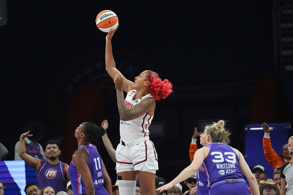Washington Mystics center Shakira Austin, center, shoots over Phoenix Mercury forward Valeriane Ayayi (11) as Mercury guard Sami Whitcomb (33) looks on during the first half of a WNBA basketball game, Thursday, Aug. 27, 2026, in Phoenix. (AP Photo/Ross D. Franklin)