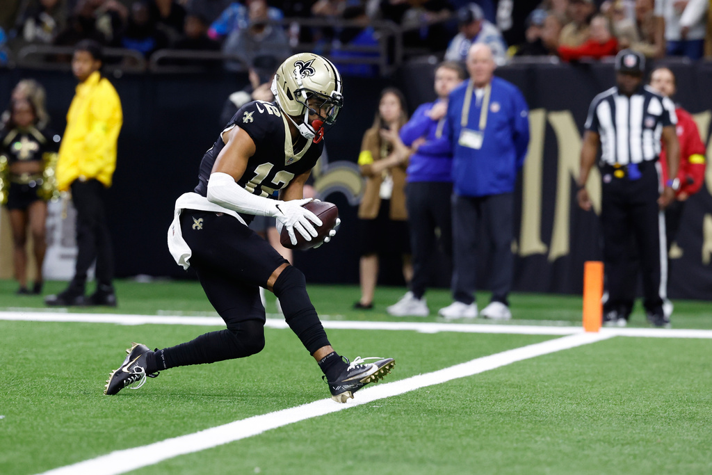 New Orleans Saints wide receiver Chris Olave (12) scores a touchdown in the second half of an NFL football game against the Carolina Panthers, Sunday, Dec. 14, 2025, in New Orleans. (AP Photo/Butch Dill)