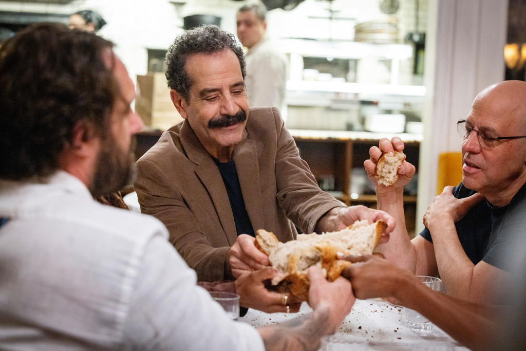 This image released by CNN shows Tony Shalhoub, center, in a scene from his series "Breaking Bread," which follows the actor across the globe as he explores cultures and food through the lens of bread. (CNN via AP)