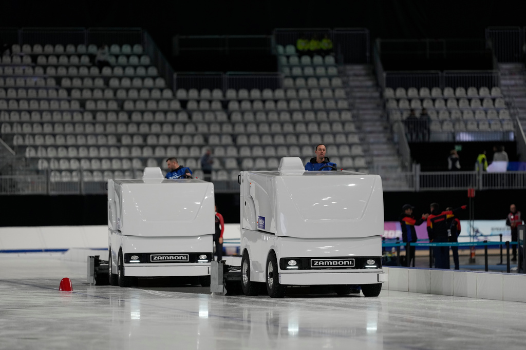 Workers clean the ice surface during a speed skating Junior World Cup and Olympic test event, in Rho, near Milan, Italy, Saturday, Nov. 29, 2025. (AP Photo/Luca Bruno)
