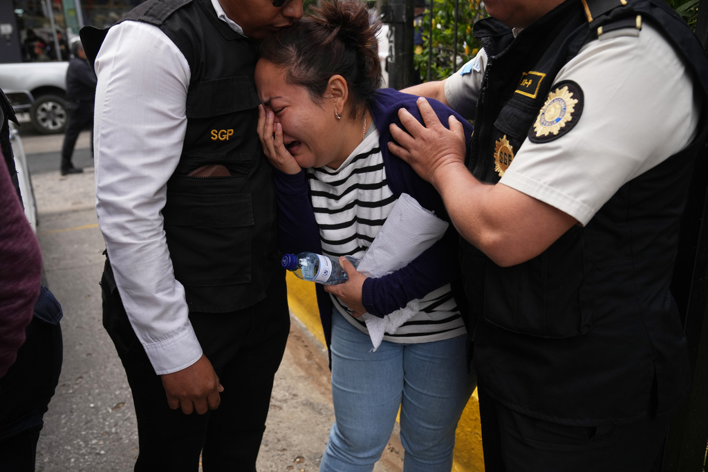 Police officers comfort a relative of one of the police officers killed while retaking control of three prisons, during the wake for the officers at the Interior Ministry in Guatemala City, Monday, Jan. 19, 2026. (AP Photo/Moises Castillo)