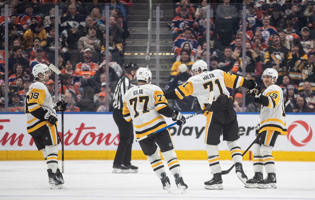 Pittsburgh Penguins' Tommy Novak (18), Brett Kulak (77), Evgeni Malkin (71) and Connor Dewar (19) celebrate after a goal against the Edmonton Oilers during second-period NHL hockey game action in Edmonton, Alberta, Thursday, Jan. 22, 2026. (Jason Franson/The Canadian Press via AP)