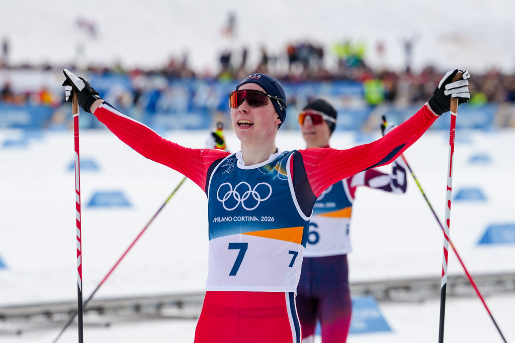 Jens Luraas Oftebro, of Norway, crosses the finish line ahead of Johannes Lamparter, of Austria, background, to win the gold medal in the Nordic Combined Individual Gundersen Normal Hill/10km competition at the 2026 Winter Olympics, in Tesero, Italy, Wednesday, Feb. 11, 2026. (AP Photo/Evgeniy Maloletka)