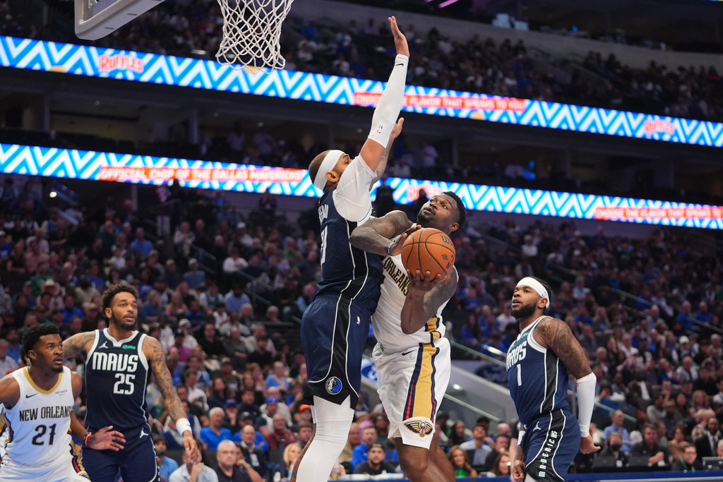 New Orleans Pelicans forward Zion Williamson (1) tries to score against Dallas Mavericks forward Daniel Gafford (21) as Pelicans center Yves Missi (21) looks on with Mavericks defenders P.J. Washington (25) and Jaden Hardy (1) during the first half of an NBA Cup basketball game in Dallas, Friday, Nov. 21, 2025. (AP Photo/LM Otero)