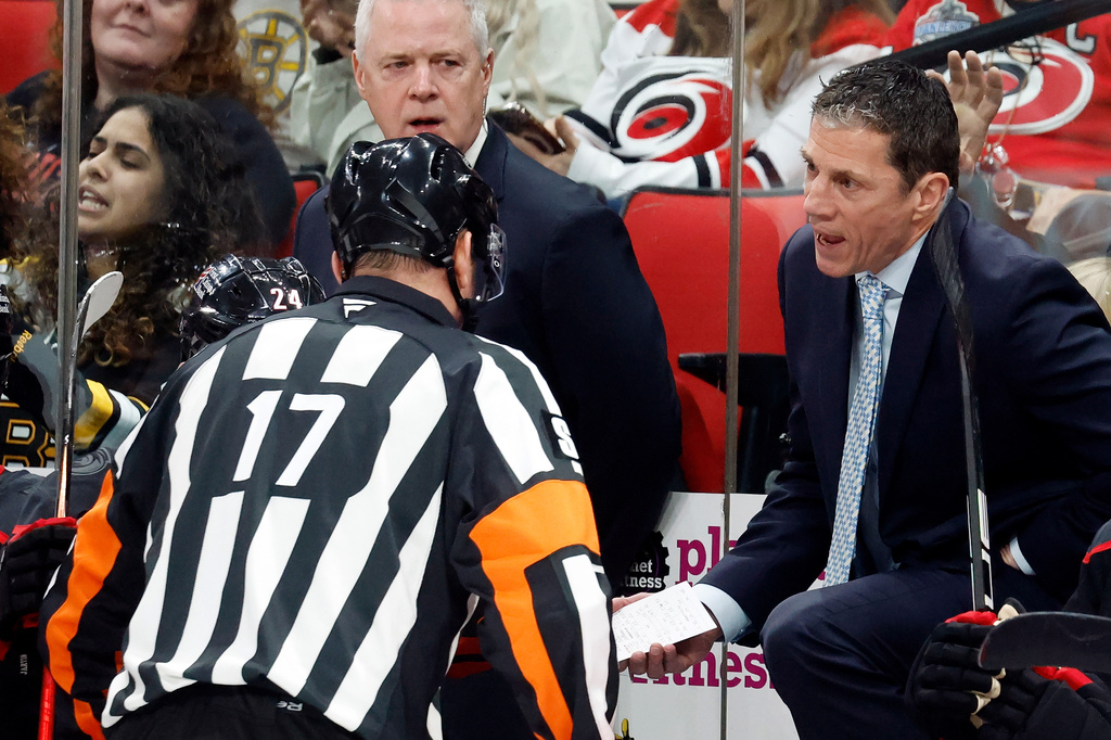 Carolina Hurricanes' Rod Brind'Amour, right, uses a coaches challenge for goalie interference with referee Frederick L'ecuyer (17) during the first period of an NHL hockey game in Raleigh, N.C., Tuesday, April 7, 2026. (AP Photo/Karl DeBlaker)