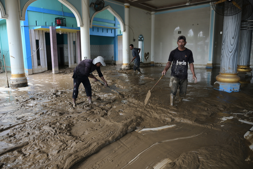 People clean up mud from a mosque at a village affected by the floods in Pidie Jaya, Aceh province, Indonesia, Wednesday, Dec. 3, 2025. (AP Photo/Reza Saifullah)