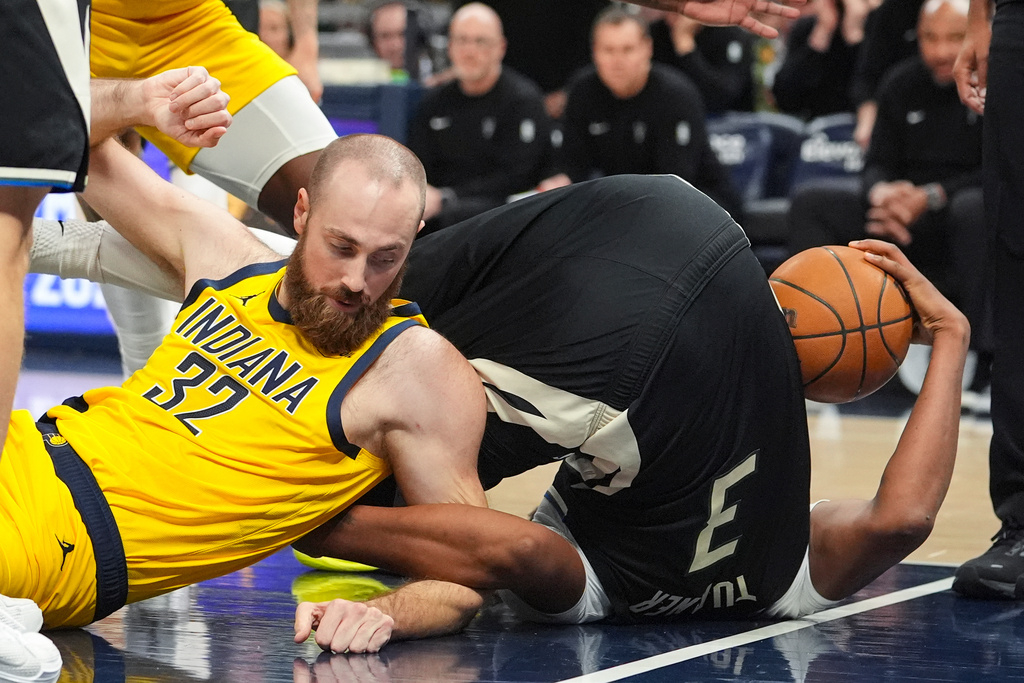 Indiana Pacers center Jay Huff (32) and Milwaukee Bucks forward Myles Turner (3) go to the floor as they scramble for a loos ball during the second half of an NBA basketball game in Indianapolis, Monday, Nov. 3, 2025. (AP Photo/Michael Conroy)