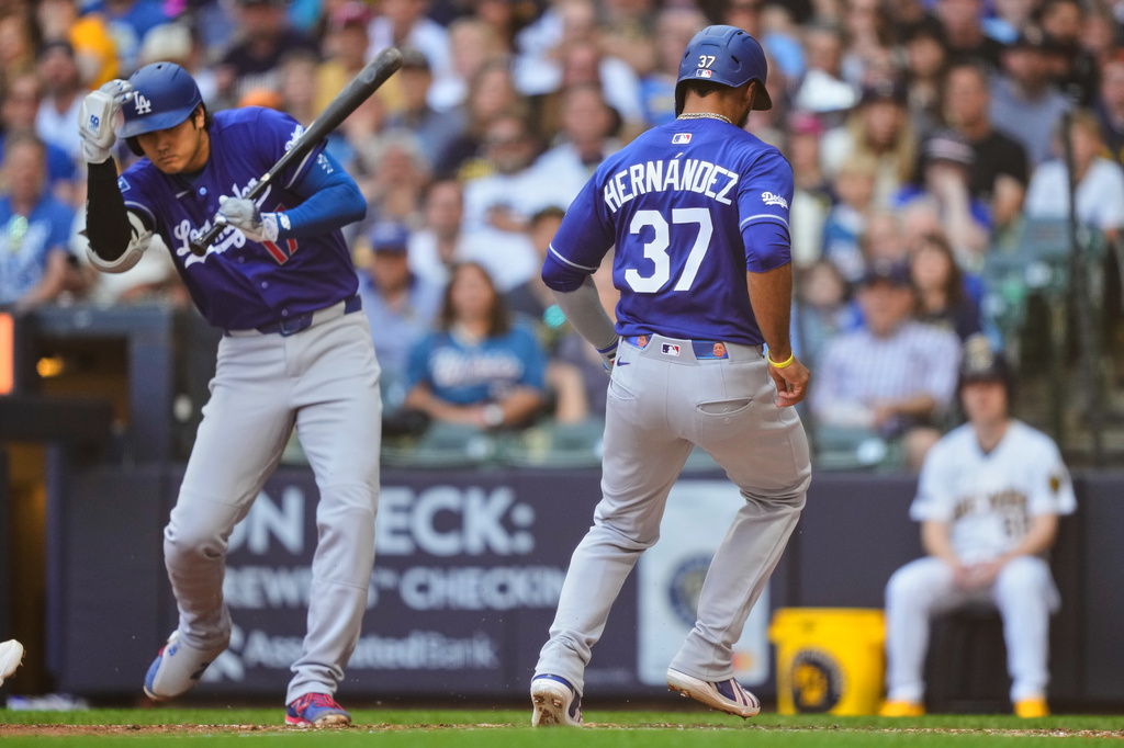 Los Angeles Dodgers' Teoscar Hernández (37) scores on a wild pitch as Shohei Ohtani, left, reacts during the fourth inning of a baseball game against the Milwaukee Brewers, Sunday, May 24, 2026, in Milwaukee. (AP Photo/Kayla Wolf)