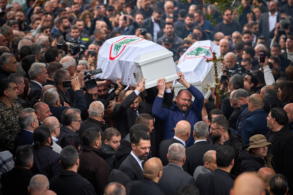 Men carry the coffins with the bodies of Pierre Mouawad, an official with the anti-Hezbollah Lebanese Forces party, and his wife during their funeral in Yahshush, Lebanon, Tuesday, April 7, 2026. (AP Photo/Emilio Morenatti)