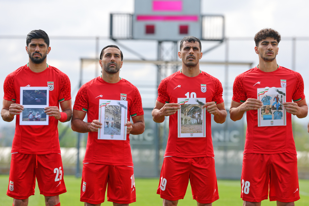 Iran's players sing the national anthem, holding pictures of children allegedly killed in U.S. and Israel strikes in Iran, before a friendly soccer match between Iran and Costa Rica, in Antalya, southern Turkey, Tuesday, March 31, 2026. (AP Photo/Riza Ozel)