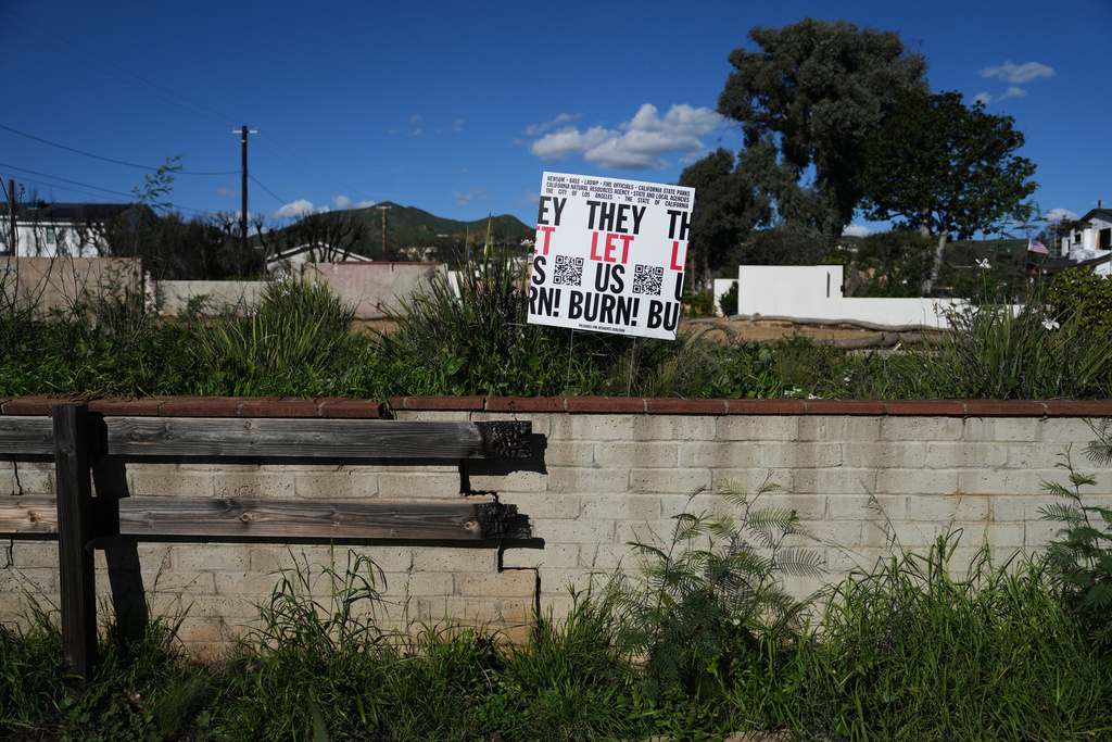 A sign is placed on a fire-damaged property on the one-year anniversary of the Palisades Fire in the Pacific Palisades neighborhood of Los Angeles Wednesday, Jan. 7, 2026. (AP Photo/Jae C. Hong)