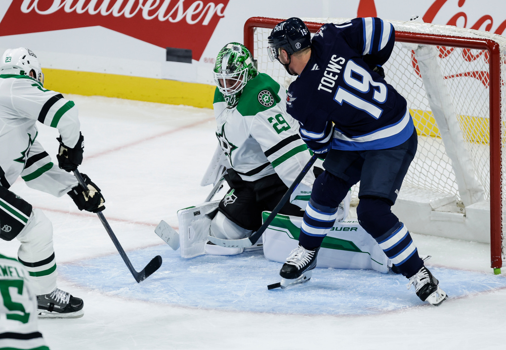 Dallas Stars' Esa Lindell (23) and goaltender Jake Oettinger (29) defend against Winnipeg Jets' Jonathan Toews (19) during second-period NHL hockey game action in Winnipeg, Manitoba, Thursday, Oct. 9, 2025. (John Woods/The Canadian Press via AP)