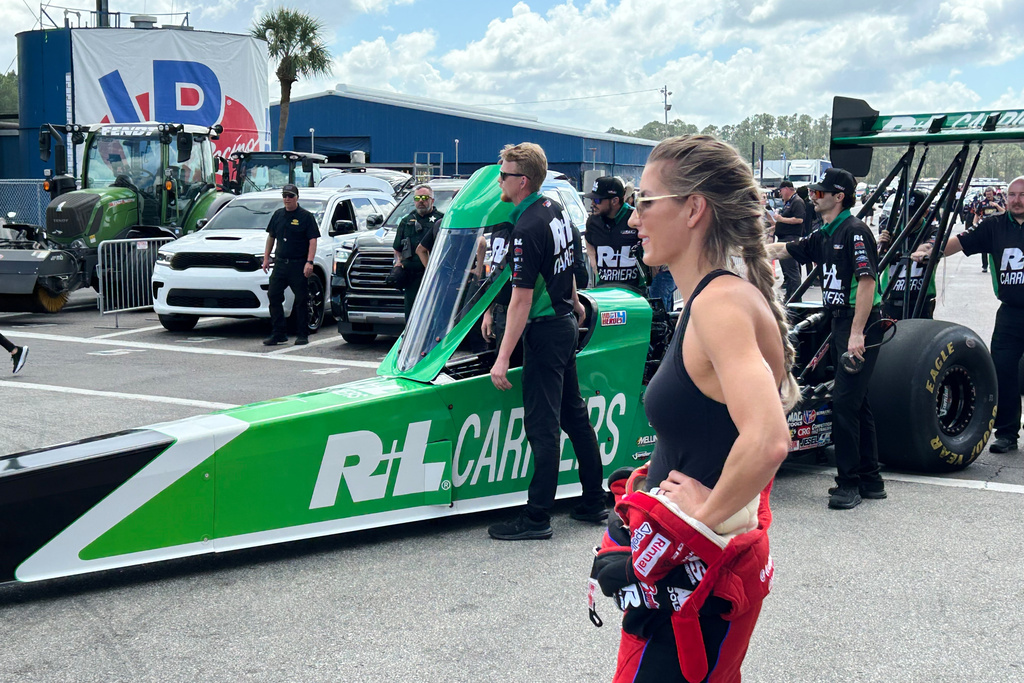 NHRA driver Leah Pruett watches as her husband, fellow racer Tony Stewart, gets pushed onto the starting line at the Gatornationals, Saturday, March 7, 2026, in Gainesville, Fla. (AP Photo/Mark Long)
