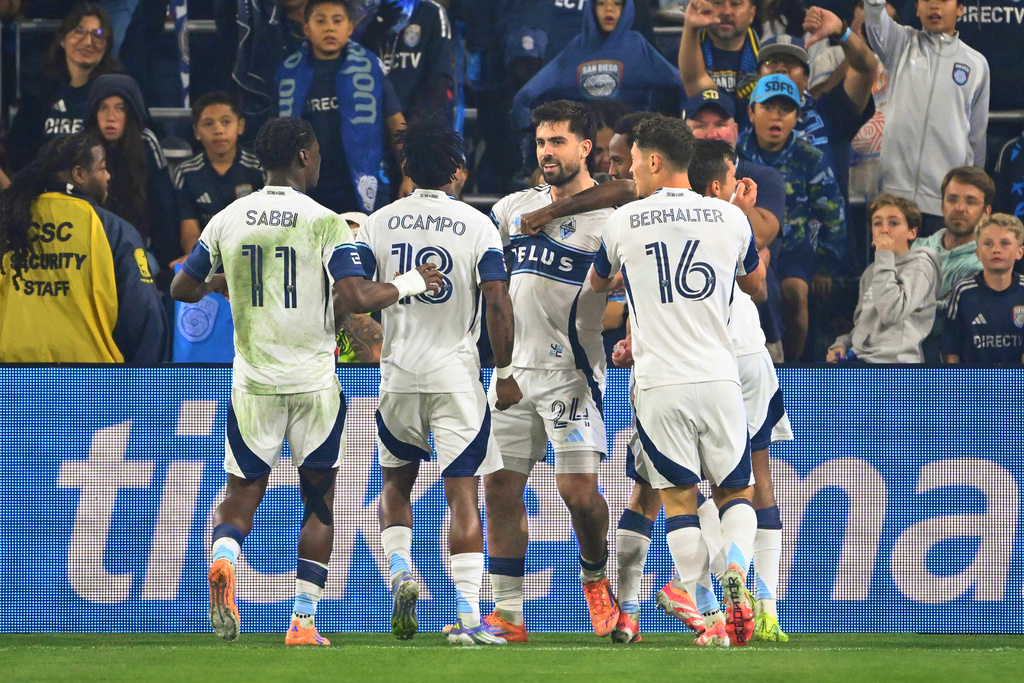 Vancouver Whitecaps forward Brian White (24), center, is congratulated after scoring during the first half of an MLS Western Conference final soccer match against San Diego FC, Saturday, Nov. 29, 2025, in San Diego. (AP Photo/Denis Poroy)