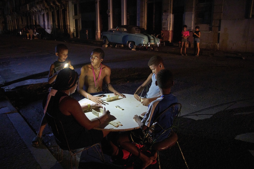 People play dominoes on the street during a blackout in Havana, Wednesday, Sept. 10, 2025. (AP Photo/Ramon Espinosa)