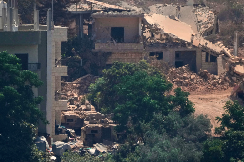 Israeli military vehicles, left, are seen stationed among homes in the village of Zawtar al-Sharqiyah, occupied by Israeli forces, is seen from the southern village of Zawtar al-Gharbieh, Lebanon, Wednesday, Aug. 5, 2026. (AP Photo/Mohammed Zaatari)