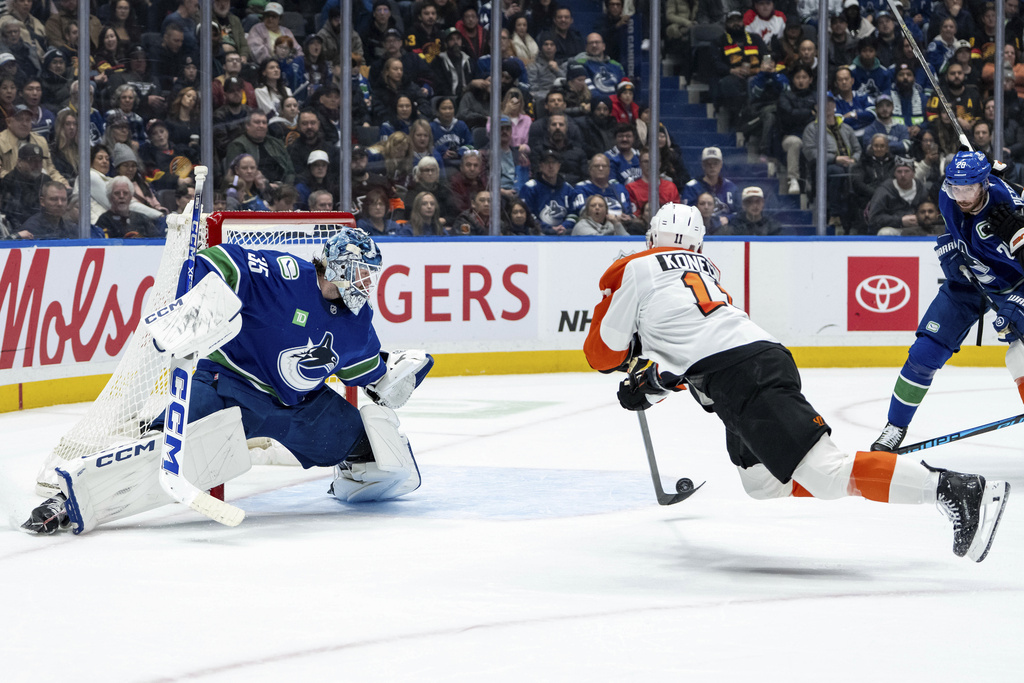 Philadelphia Flyers' Travis Konecny (11) scores on Vancouver Canucks goaltender Thatcher Demko (35) during the second period of an NHL hockey game in Vancouver, B.C., Tuesday, Dec. 30, 2025. (Ethan Cairns/The Canadian Press via AP)
