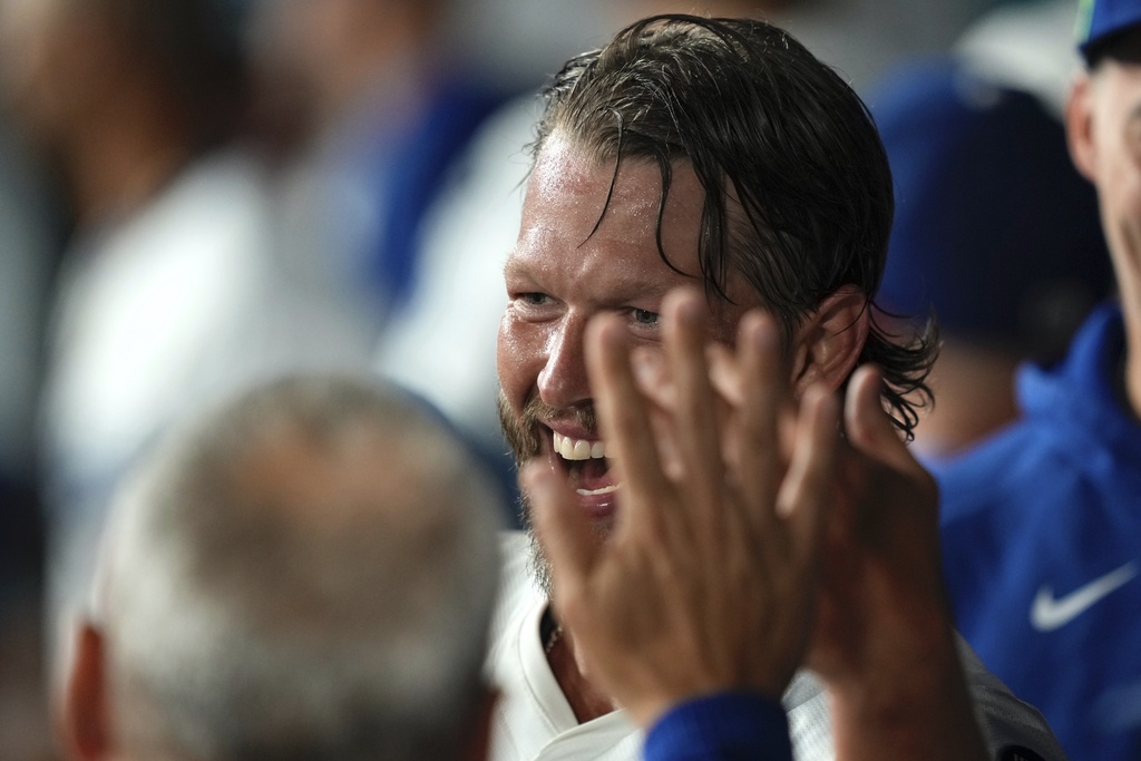 Los Angeles Dodgers starting pitcher Clayton Kershaw is congratulated by teammates in the dugout after finishing the sixth inning of a baseball game against the San Diego Padres, Friday, Aug. 15, 2025, in Los Angeles. (AP Photo/Mark J. Terrill)