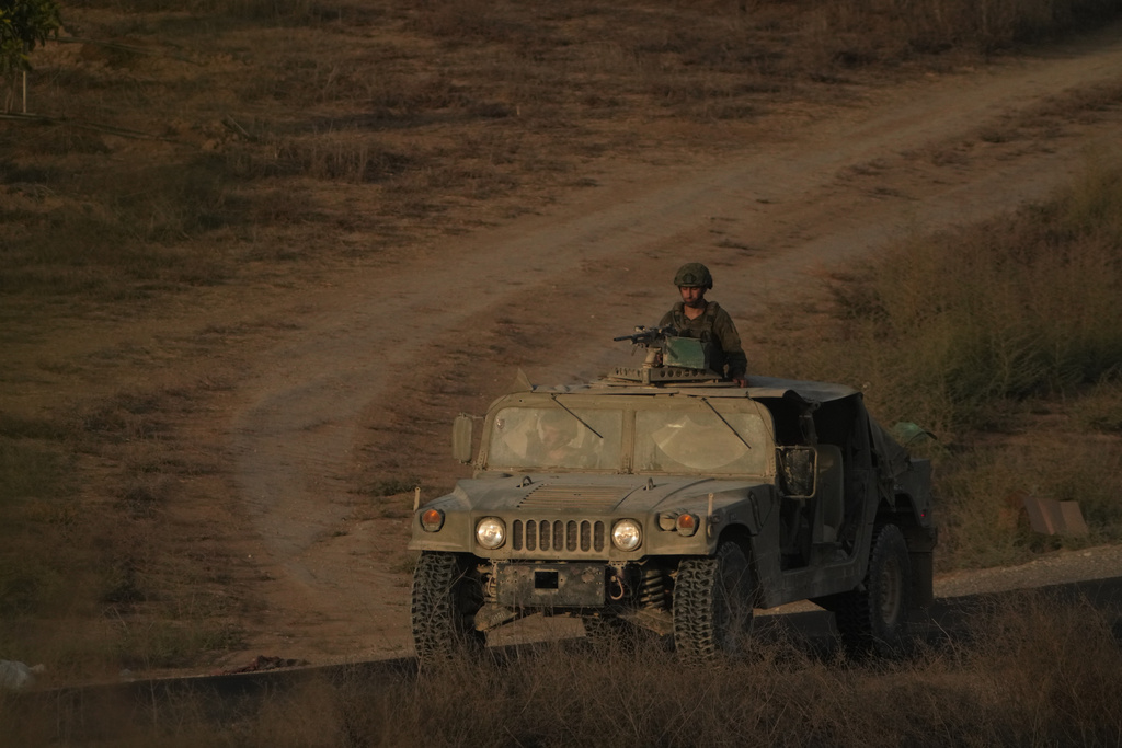 Israeli soldiers move near the Israeli-Gaza border, as seen from southern Israel, Thursday, Oct. 9, 2025, following the announcement that Israel and Hamas have agreed to the first phase of a peace plan to pause the fighting. (AP Photo/Ariel Schalit)