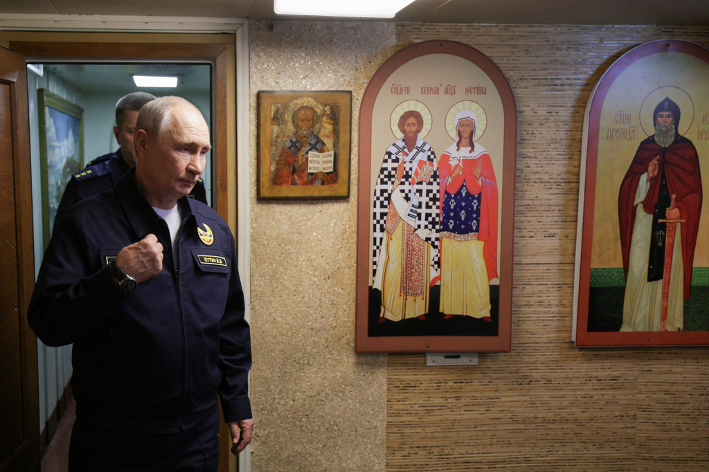 Russian President Vladimir Putin crosses himself as he visits the Varyag missile cruiser of the Pacific Fleet to watch a military exercise near Yuzhno-Sakhalinsk, on Sakhalin Island, Russia, Wednesday, Aug. 12, 2026. (Gavriil Grigorov, Sputnik, Kremlin Pool Photo via AP)