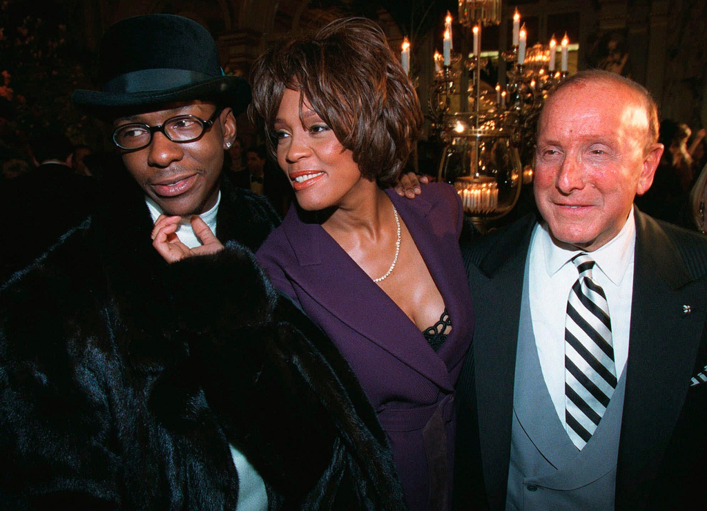 FILE - Bobby Brown, left, and Whitney Houston appear with music producer Clive Davis, right, at a pre-Grammy party in New York on Feb. 24, 1998. (AP Photo/Stuart Ramson, File)