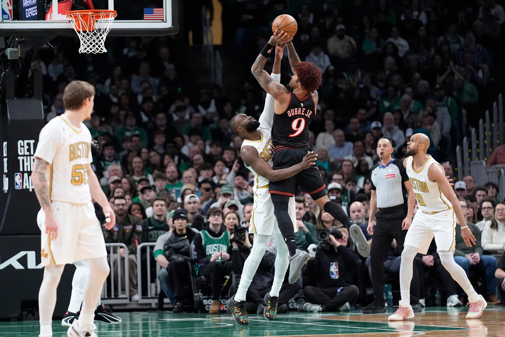 Philadelphia 76ers guard Kelly Oubre Jr. (9) goes up to shoot over Boston Celtics guard Jaylen Brown, center left, during the first half of an NBA basketball game, Sunday, March 1, 2026, in Boston. (AP Photo/Robert F. Bukaty)