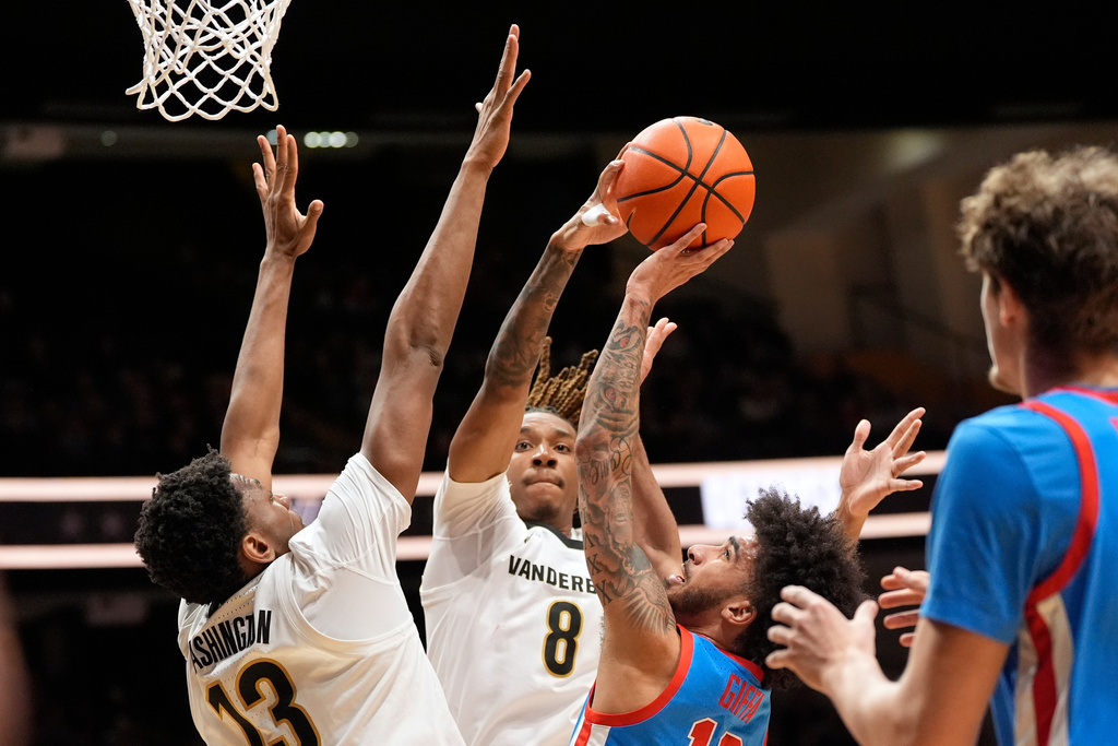 Mississippi guard Kezza Giffa, right, shoots the ball against Vanderbilt guard Tyler Harris (8) and forward Jalen Washington (13) during the first half of an NCAA college basketball game Saturday, Jan. 31, 2026, in Nashville, Tenn. (AP Photo/George Walker IV)