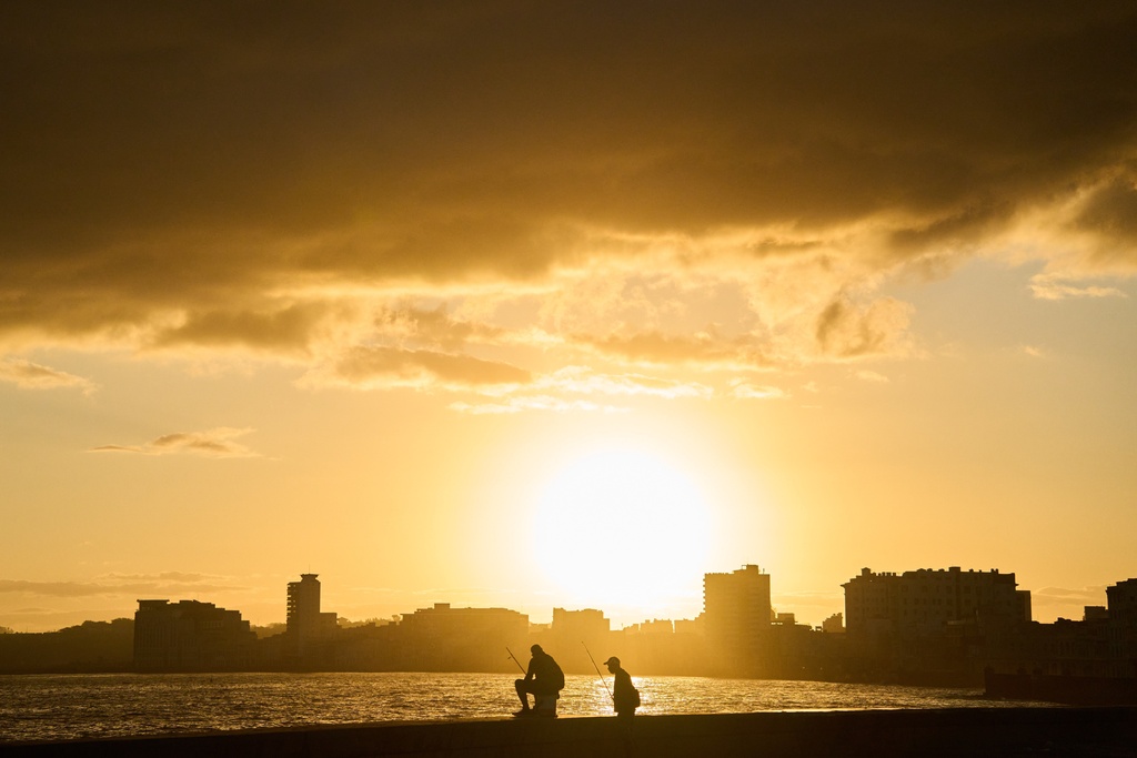 Fishermen are seen on the Malecón seawall at dawn during a blackout in Havana, Cuba, Sunday, March 22, 2026. (AP Photo/Ramon Espinosa)