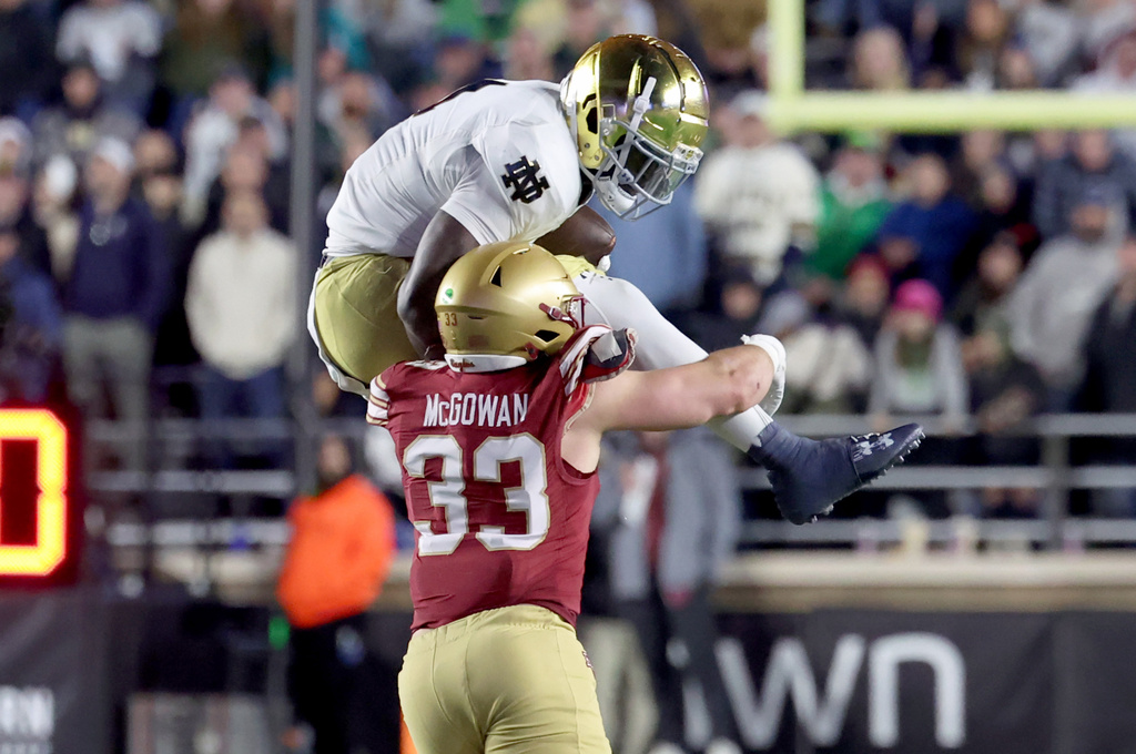 Notre Dame running back Jeremiyah Love maneuvers over Boston College linebacker Owen McGowan carrying the ball during the second half of an NCAA college football game Saturday, Nov. 1, 2025, in Boston. (AP Photo/Mark Stockwell)