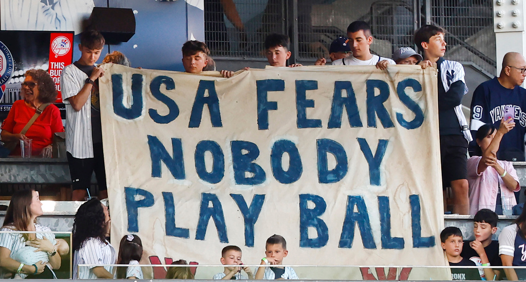 New York Yankees fans share a message during a 9/11 ceremony before baseball game against the New York Mets, Friday, Sept. 11, 2026, in New York. (AP Photo/Noah K. Murray)